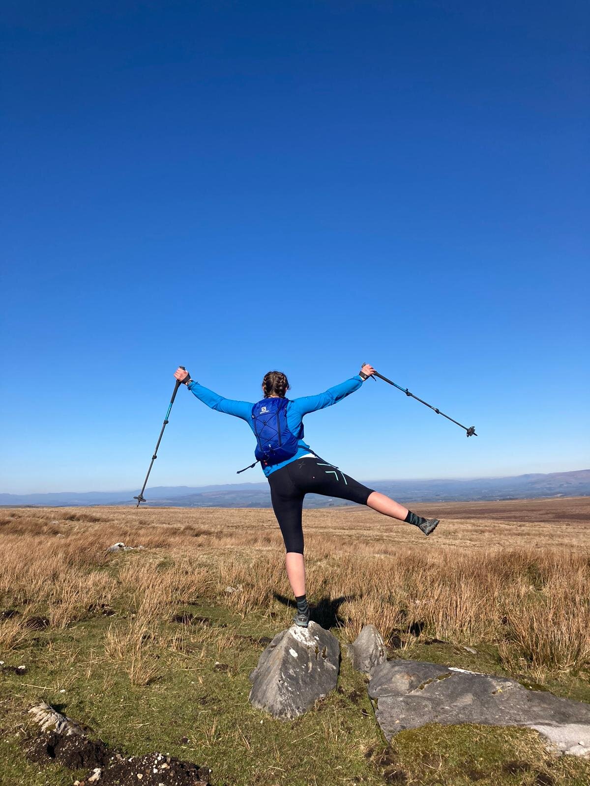 celebrating running 100km - woman against blue sky