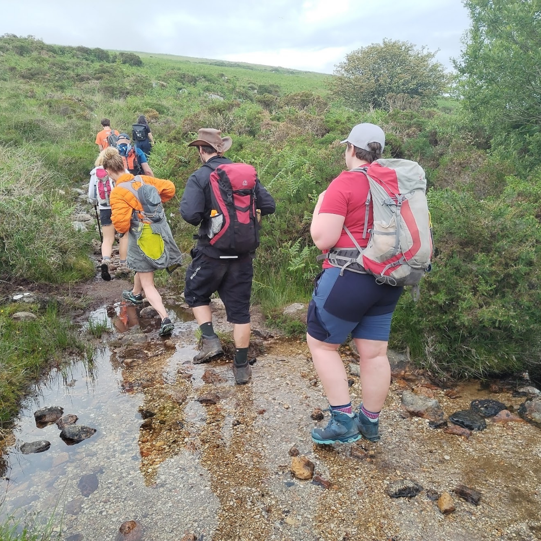 group hiking on Dartmoor crossing stream