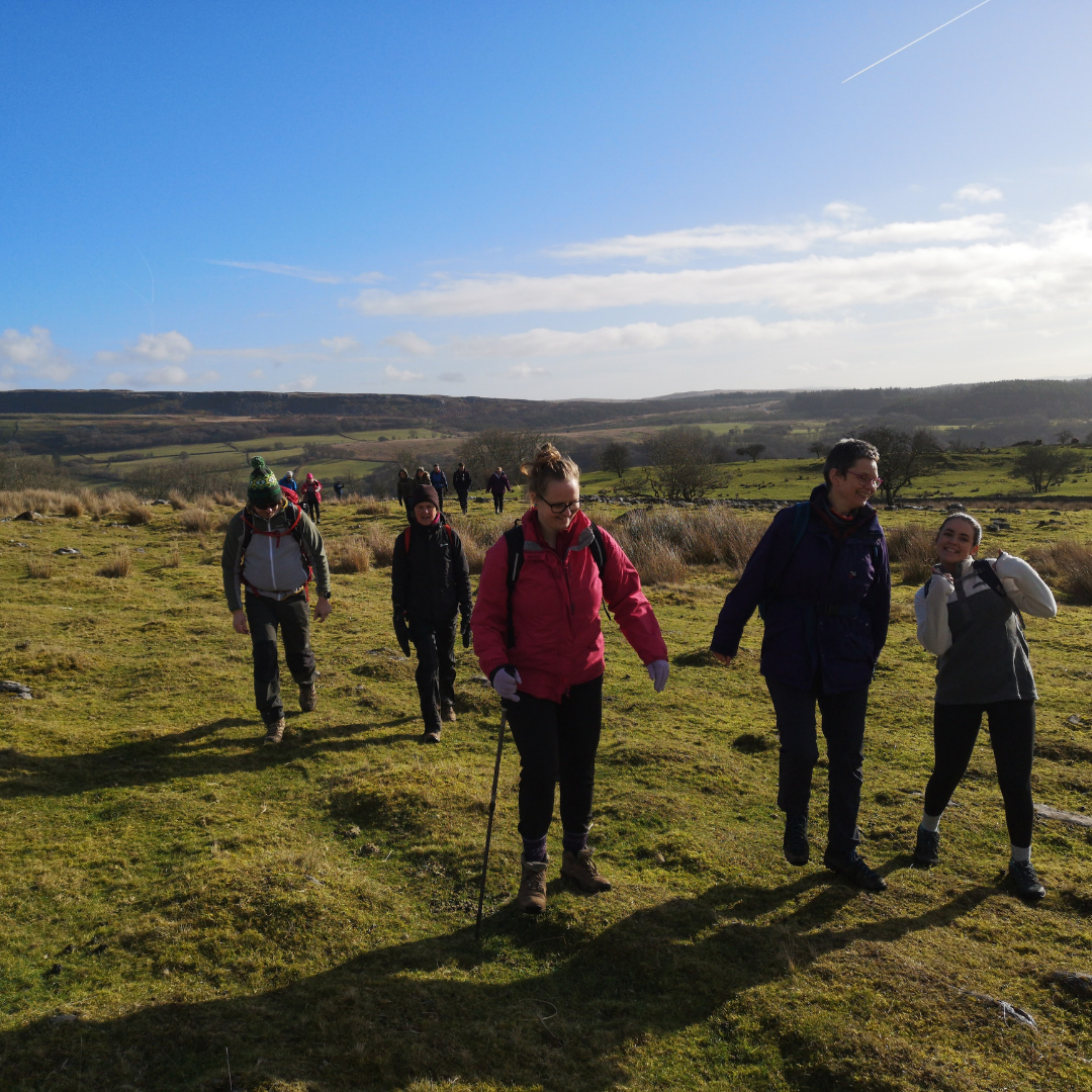 happy walking group - hiking witih mind over mountains sunny day green grass