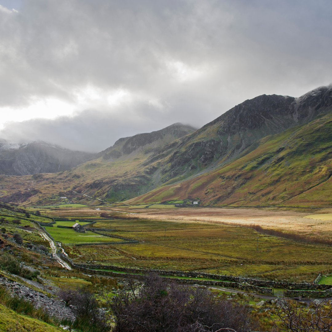 Valley with mountains under a cloudy sky