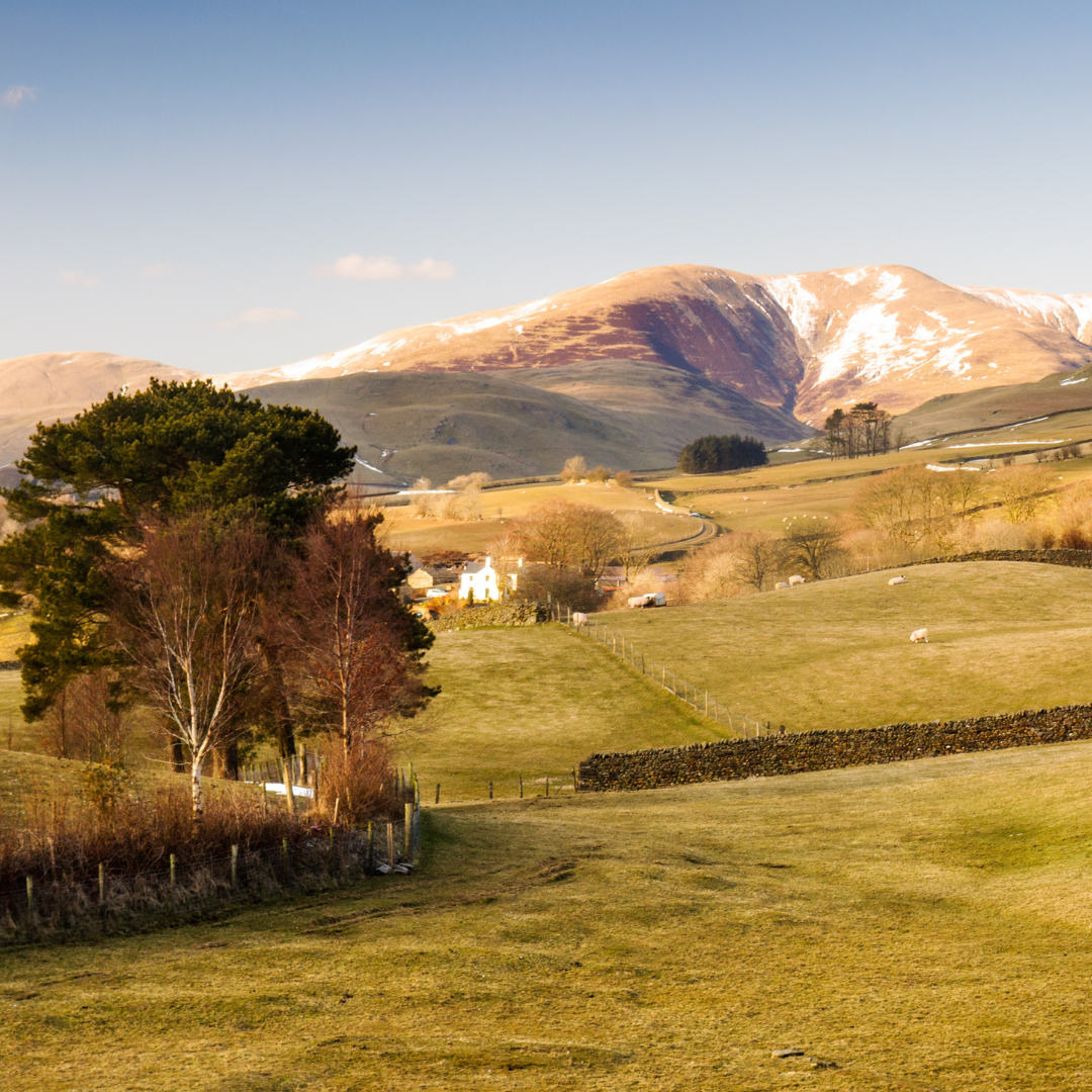 Scenic view of a mountain range with snow-capped peaks in a valley.