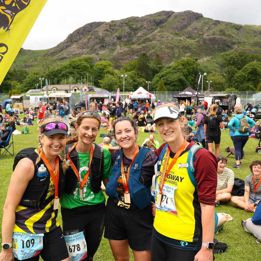 four women with medals celebrate finishing a Lakeland Trails race 