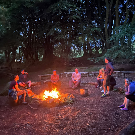 campfire during Mind Over Mountains retreat - group seated around fire