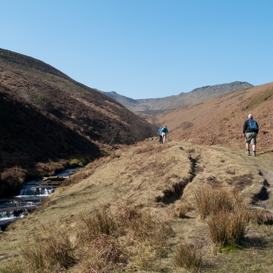 hikers walking in Edale beside river on wellbeing walk with Mind Over Mountains charity