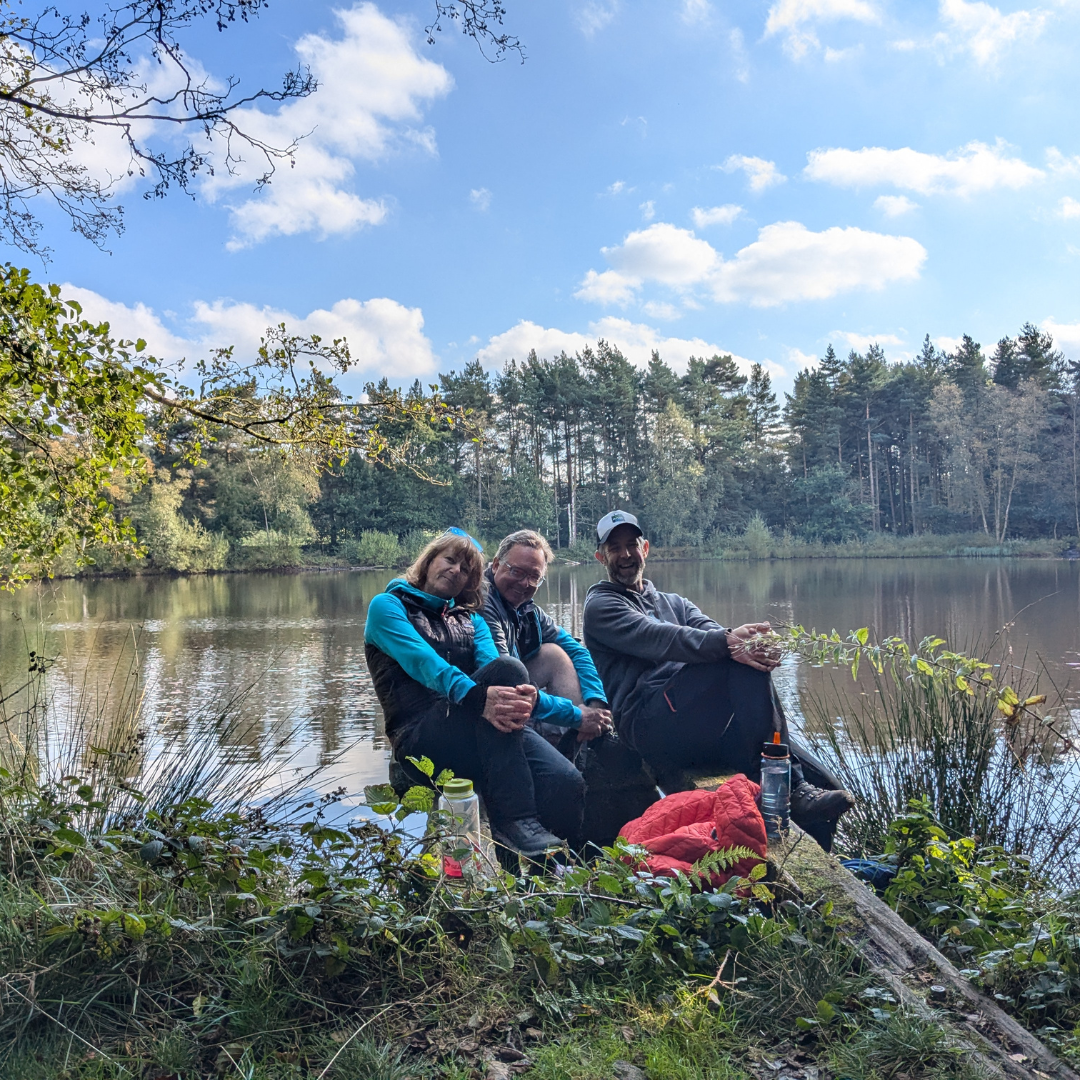 Hikers smiling while sitting on peak district lakeside