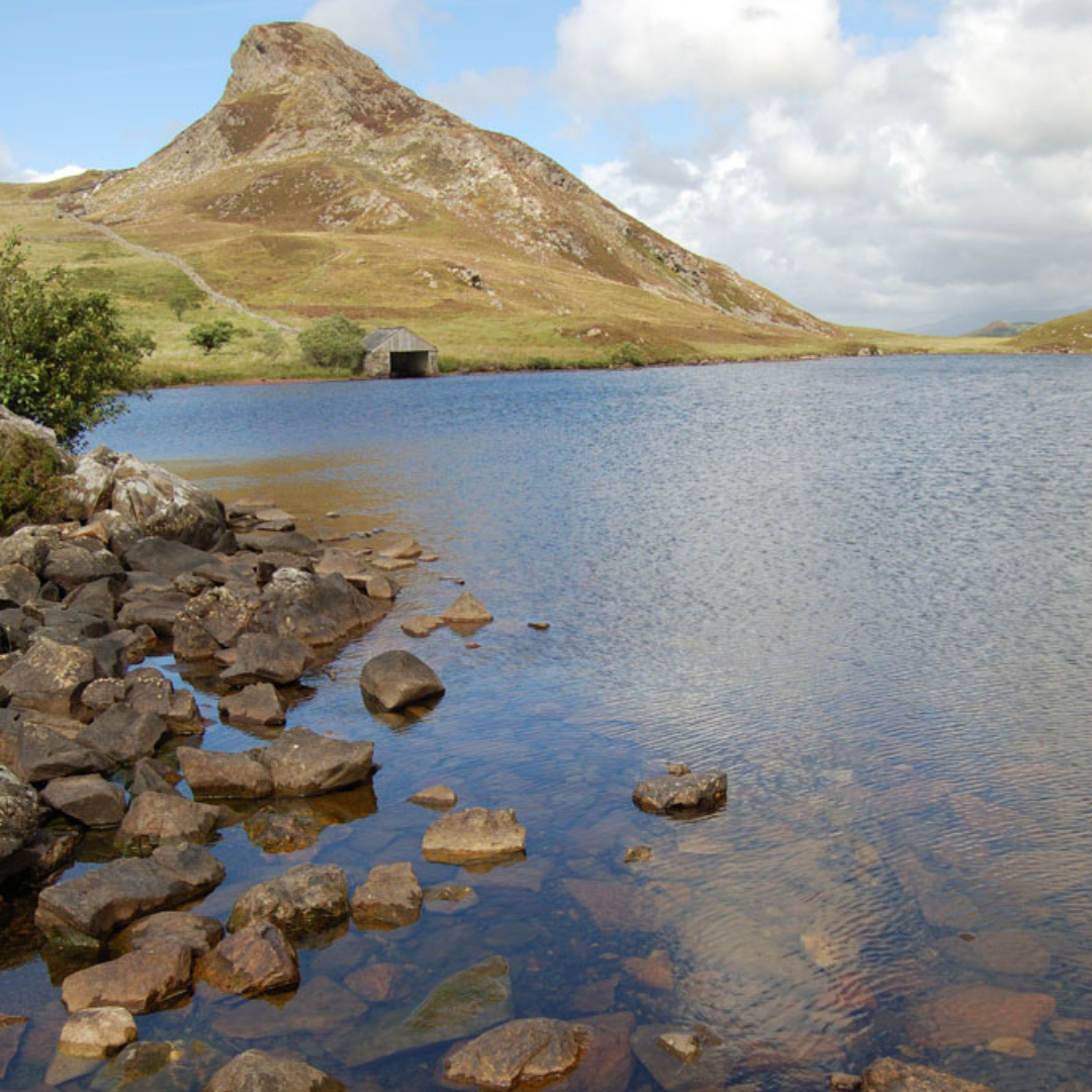 scenery in Wales lake with rocks and peak
