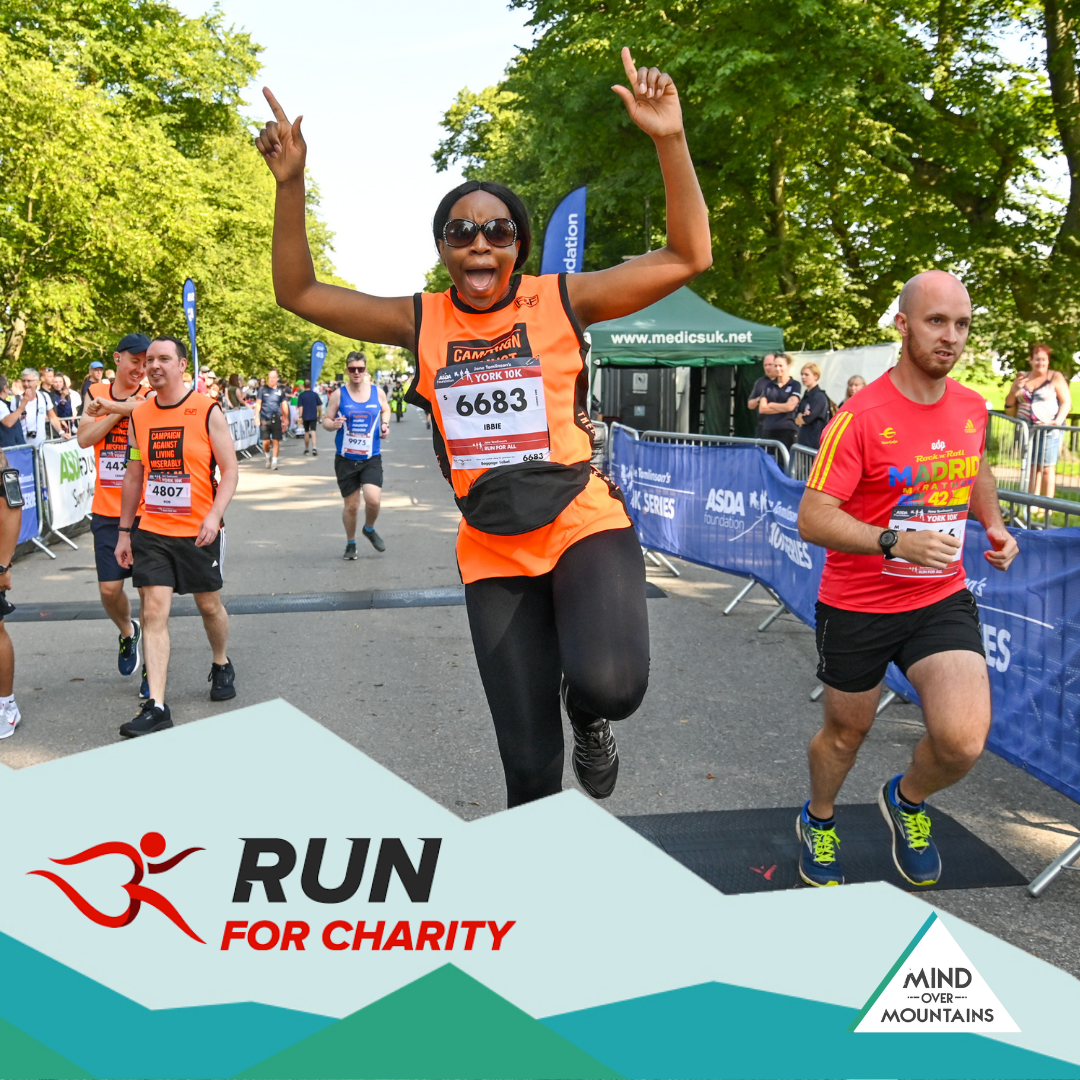 runner at finish line celebrating with other runners around - running charity event