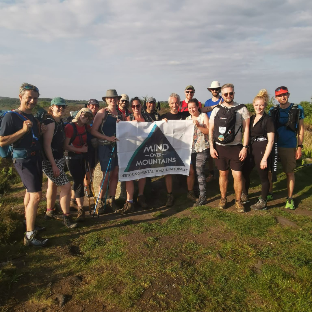 hiking group Mind Over Mountains wellbeing charity standing together with flag