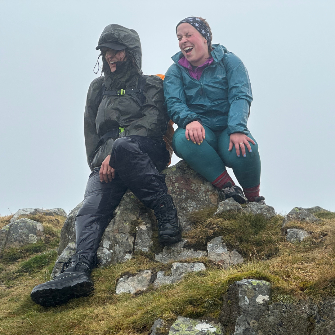 2 female hikers laughing in wet weather