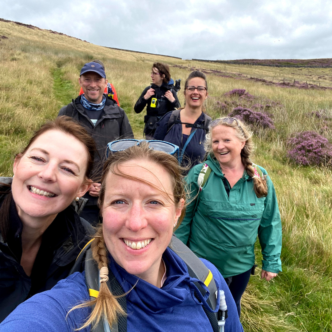 hiking selfie - group of walkers on hillside with grass and heather