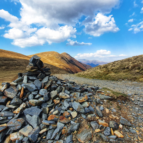 view of a slate cairm and mountains in the Lake District 