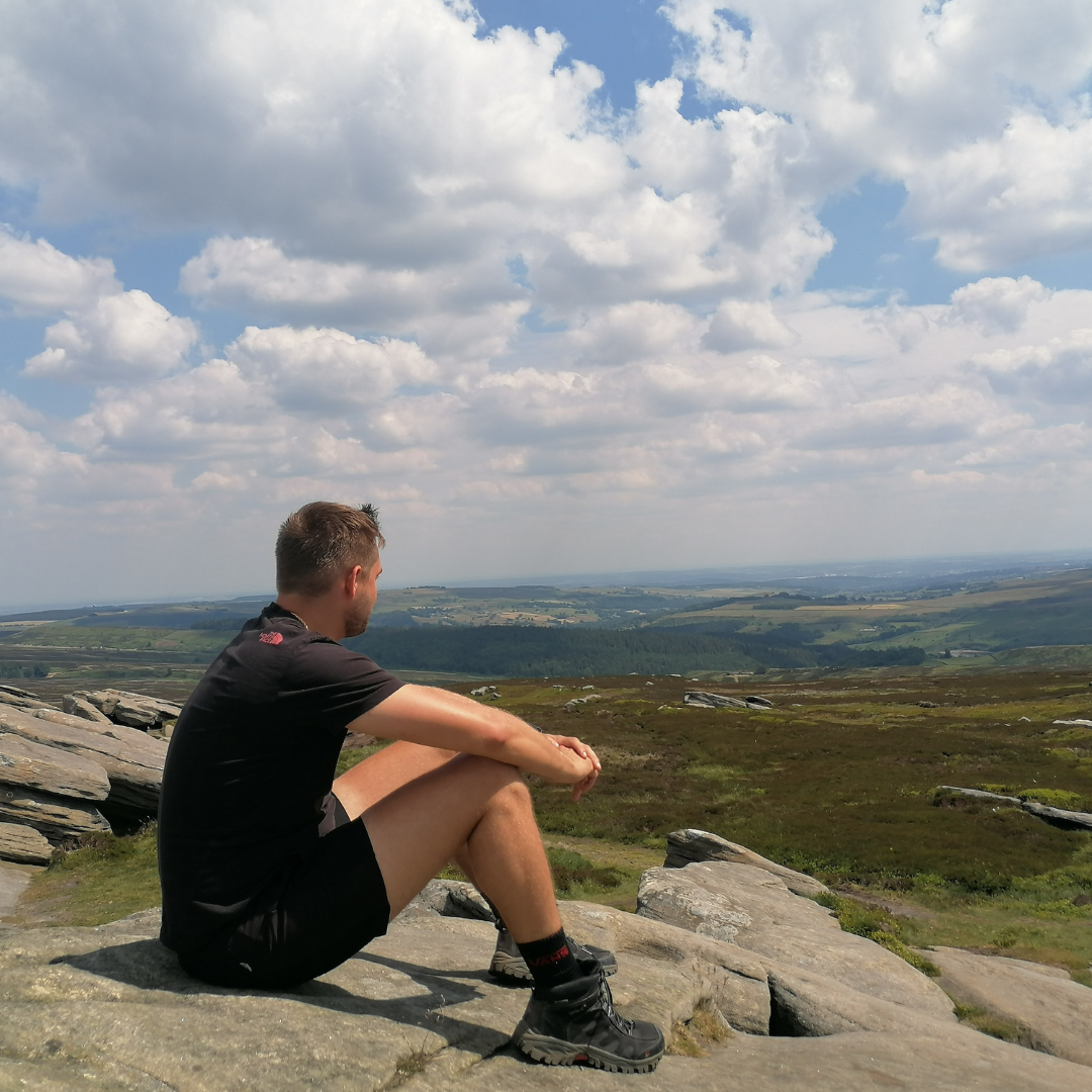 man seated practising mindfulness looking at Dartmoor view