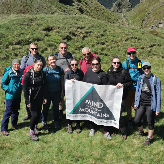 hiking group with Mind Over Mountains charity banner