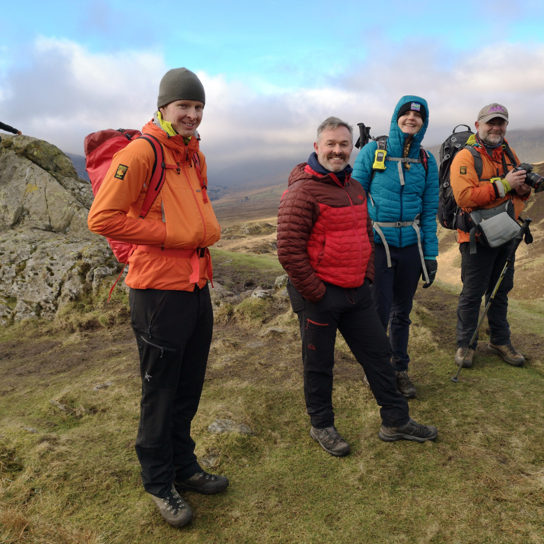mountain leaders on mental fitness hike - four people in outdoor gear in hills